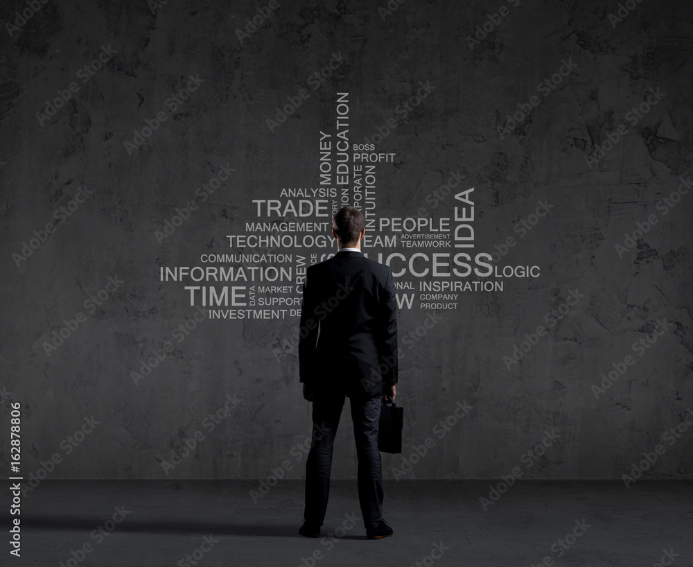 Businessman with briefcase standing over wall with text. Business, success, improvement, concept.