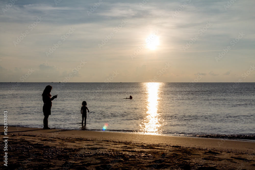 Father, mother, and child Enjoy the sea at dawn