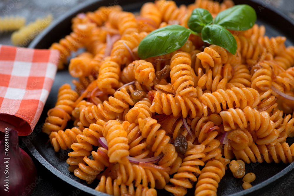 Close-up of fusilli wheat pasta with red onion sauce, selective focus Close-up of fusilli wheat pasta with red onion sauce, selective focus