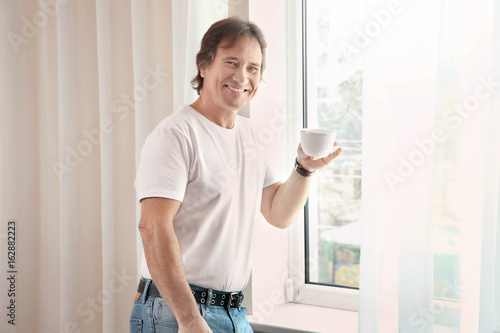 Mature man with cup of coff...