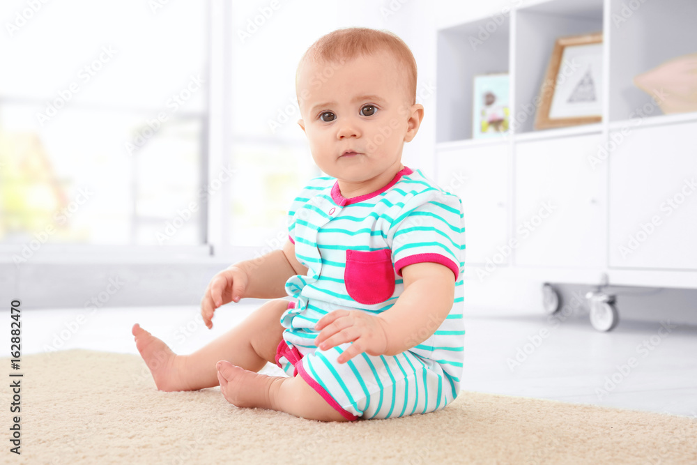 Cute little baby sitting on floor at home Cute little baby sitting on floor at home