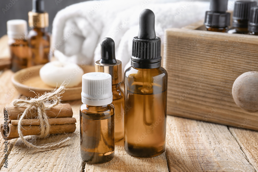 Composition with bottles of cinnamon oil on wooden background Composition with bottles of cinnamon oil on wooden background