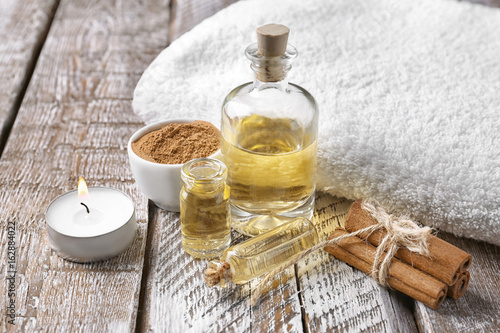 Foto Composition with bottles of cinnamon oil on wooden background