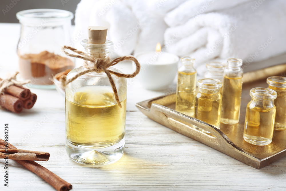 Composition with bottles of cinnamon oil on wooden background Composition with bottles of cinnamon oil on wooden background