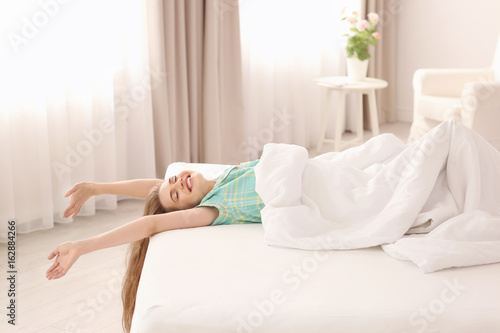 Morning of beautiful young woman lying on bed at home