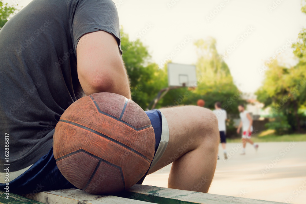 Fototapeta premium Basketball ball and player with defocused sports playground.