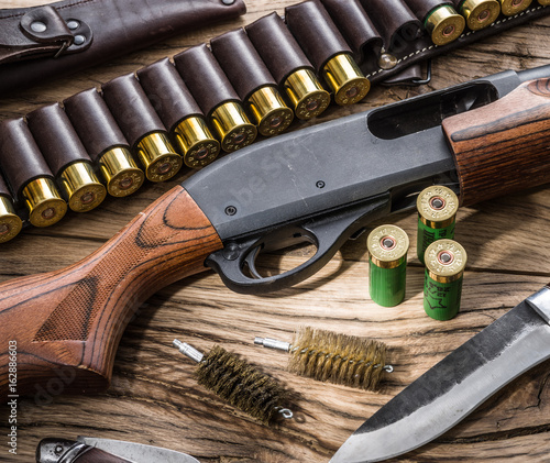 Pump action shotgun, 12 guage cartridge and hunting knife.