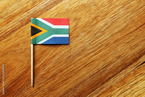 A small South African flag isolated on a wooden background.  photo