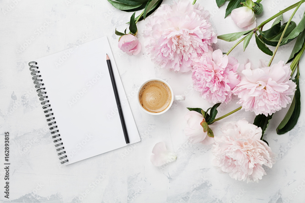 Morning coffee mug for breakfast, empty notebook, pencil and pink peony flowers on white stone table top view in flat lay style. Woman working desk. - obrazy, fototapety, plakaty 