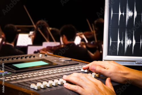 sound engineer hands working on digital sound mixer for symphony orchestra live concert recording