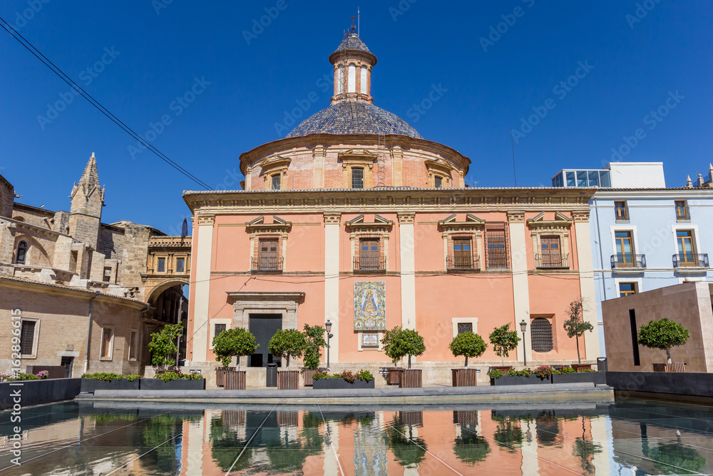 Colorful Basilica de la Virgen with reflection in the water in Valencia