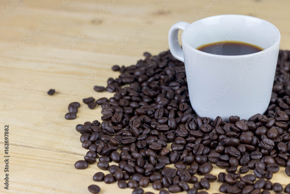 Hot coffee in white cop and coffee bean on wooden table. copy space Hot coffee in white cop and coffee bean on wooden table. copy space