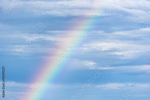 Natural rainbow and blue sky with clouds  nature background