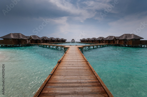 Tropical Maldives island resort with luxury water villas and wooden bridge © Maciej Matlak