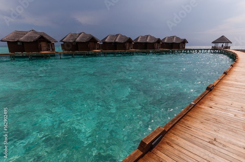 Fototapeta Naklejka Na Ścianę i Meble -  Tropical Maldives island resort with luxury water villas and wooden bridge