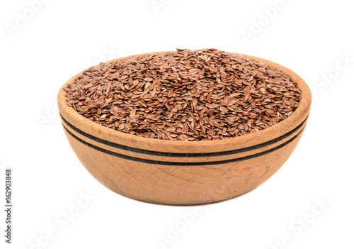Wooden bowl filled with flax seeds isolated on white background