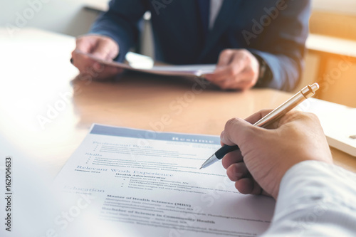 Executive reading a resume during a job interview and businessman Completing Application Form. Hiring concept