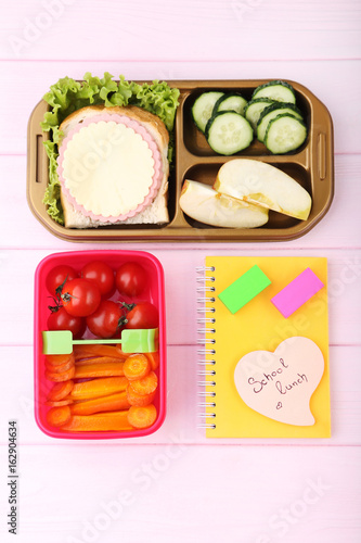 School lunch in boxes on pink wooden table