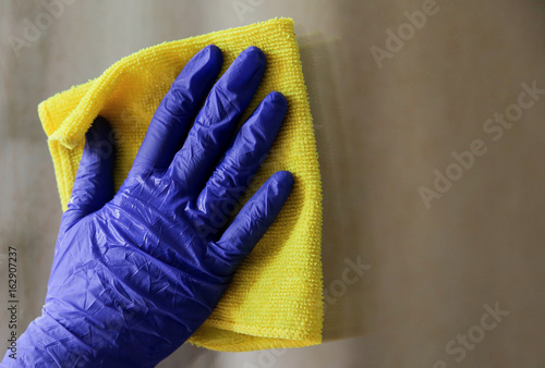 Woman cleaning a window with yellow cloth