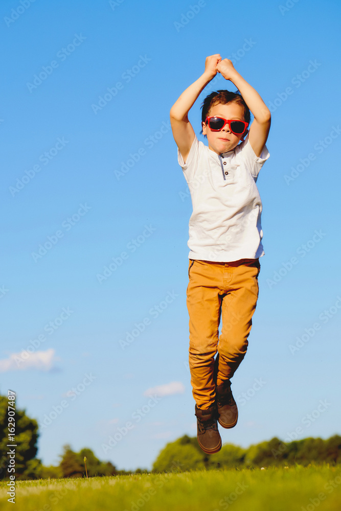 Fototapeta premium Little boy in sunglasses having fun in summer