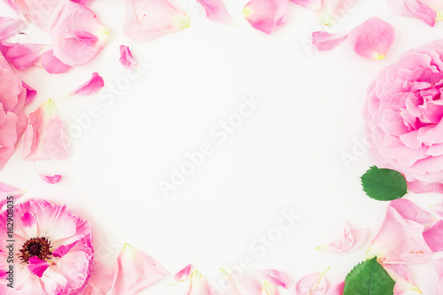 Round frame of pink flowers  petals and leaves on white background. Floral lifestyle composition. Flat lay  top view.