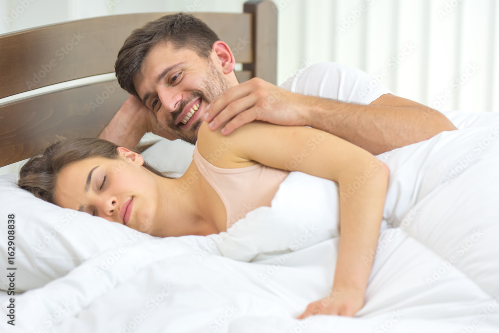 The happy man lay near a woman in the bed The happy man lay near a woman in the bed