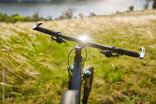 Close-up of detail of the mountain bicycle on the green grass.