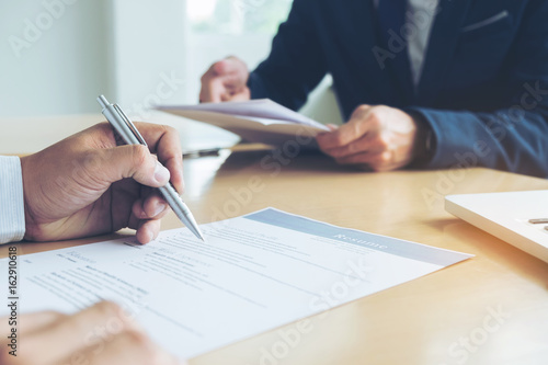 Executive reading a resume during a job interview and businessman Completing Application Form. Hiring concept photo