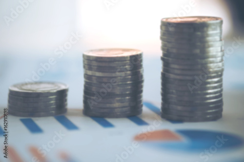 financial banking stock spreadsheet with stack of coin and background on accountant data, growth rate, finance, saving, investment, business and banking concept. blurred background