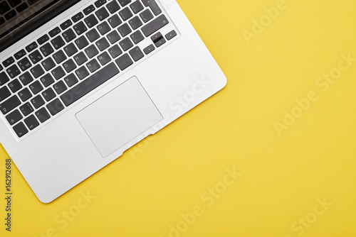 Modern laptop keyboard on yellow background
