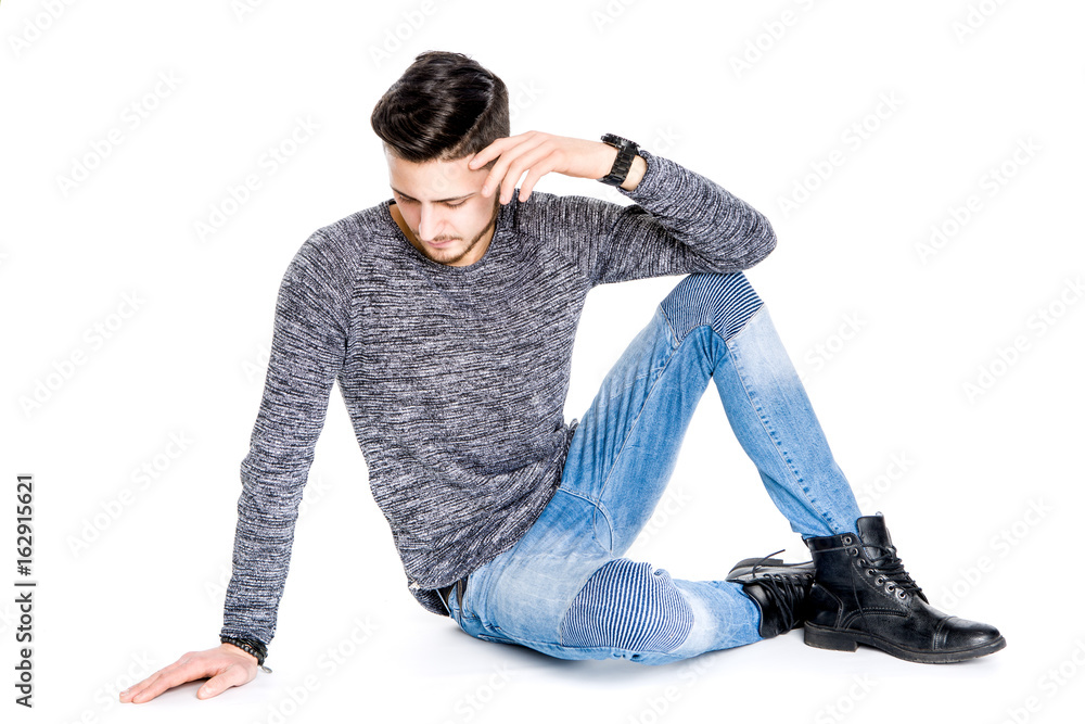 head down young brunette man sits on ground looking to floor in high key studio White Background head down young brunette man sits on ground looking to floor in high key studio White Background