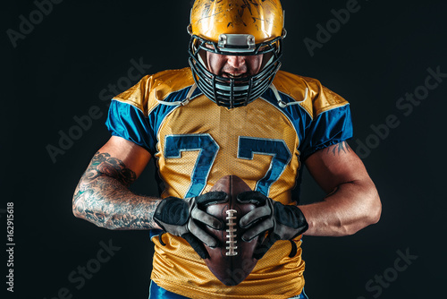 American football player holds ball in hands