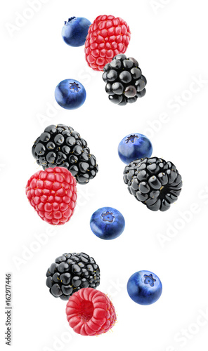 Isolated floating berries. Falling blackberry, raspberry and blueberry fruits isolated on white background with clipping path