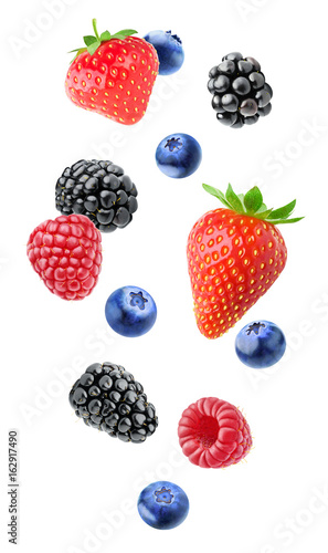 Isolated mixed berries in the air. Falling blackberry, raspberry, blueberry and strawberry fruits isolated on white background with clipping path