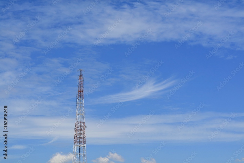 Antenna tower building with the blue sky and white cloud. Technology and nature background with copy space. Soft focus. Antenna tower building with the blue sky and white cloud. Technology and nature background with copy space. Soft focus.