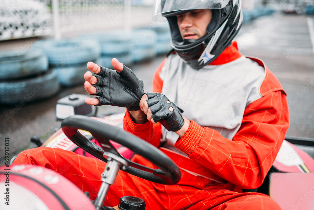 Go-kart driver in helmet on karting speed track Go-kart driver in helmet on karting speed track