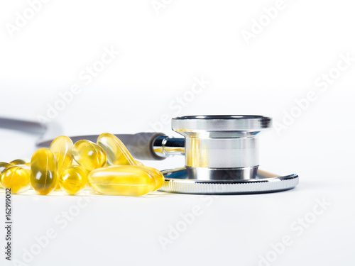 stethoscope and Cod liver oil omega 3 gel capsules on white background.