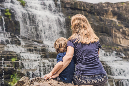 Mother and son hikers, tourists on the background of Amazing Pongour Waterfall is famous and most beautiful of fall in Vietnam. Not far from Dalat city estimate 45 Km. Dalat, Vietnam photo