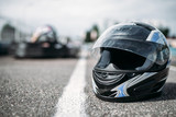 Racer helmet on asphalt, karting sport concept