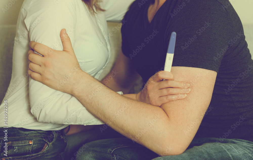 Girl with pregnancy test hugging her boyfriend. Girl with pregnancy test hugging her boyfriend.