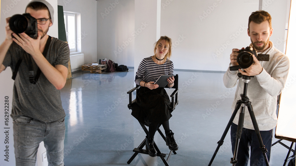 © Photodrive - Horizontal indoors shot of two photographers working while director observing. © Photodrive - Horizontal indoors shot of two photographers working while director observing.
