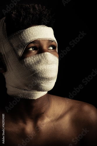 Fotografie African boy with his head swathed in a bandage