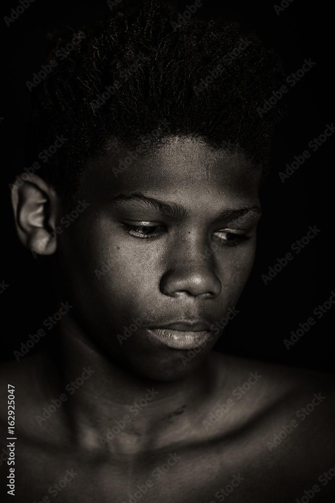 Moody monochrome portrait of a young African boy Moody monochrome portrait of a young African boy
