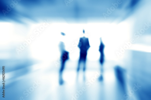 Blur abstract background of business people standing in building hall, blue theme