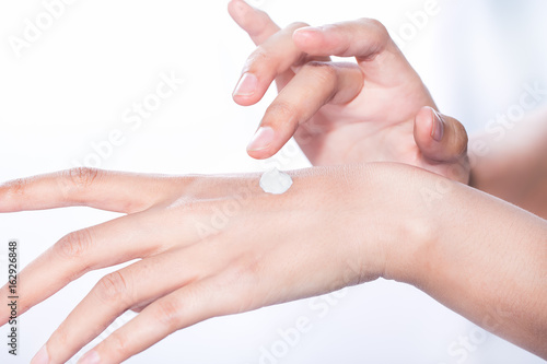 woman isolated on white studio shot applying cream on her hands