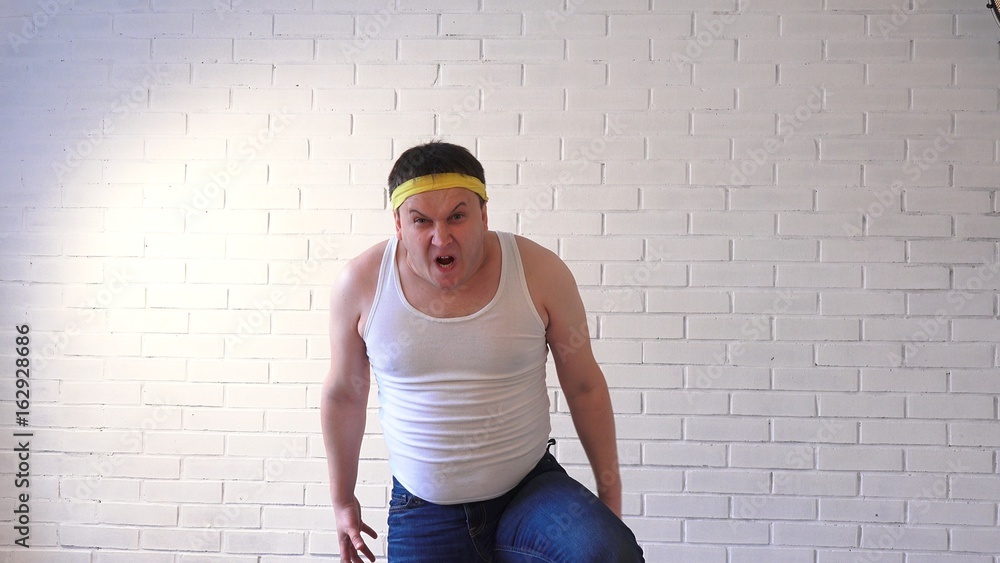 A fat man in a T-shirt looks furiously forward A fat man in a T-shirt looks furiously forward