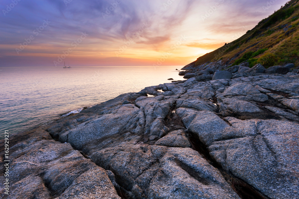 Seascape with rock in beautiful sunset scenery background.