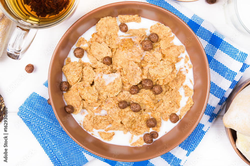 Top view of healthy breakfast. Oat cereal granola in bowl on white wooden background Top view of healthy breakfast. Oat cereal granola in bowl on white wooden background