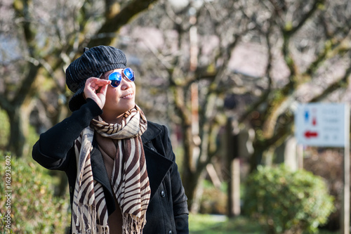 Asian senior female tourist in winter costume traveling in Dazaifu temple, Japan photo