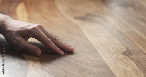 closeup of man hand checking hard wood surface